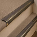 Antique Brass finish with Peat Castellated insert - 63.5mm solid brass bullnose stair nosing fitted to a carpeted step