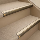 Antique Brass finish with Porth Stone Smooth Textured insert - 63.5mm solid brass bullnose stair nosing fitted to a carpeted step