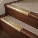 Satin Brass finish with Porth Stone Castellated insert - 63.5mm solid brass bullnose stair nosing fitted to a carpeted step