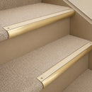 Satin Brass finish with Porth Stone Smooth Textured insert - 63.5mm solid brass bullnose stair nosing fitted to a carpeted step