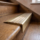 BN71SLR solid brass stair nosing in Antique Brass finish with Antique Brass insert, fitted to a step edge