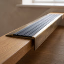 BN71SLR solid brass stair nosing in Antique Brass finish with Black Castellated insert, fitted to a step edge