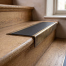 BN71SLR solid brass stair nosing in Antique Brass finish with Black Smooth Textured insert, fitted to a step edge