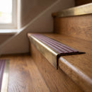 BN71SLR solid brass stair nosing in Antique Brass finish with Claret Castellated insert, fitted to a step edge