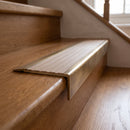 BN71SLR solid brass stair nosing in Antique Brass finish with Fawn Castellated insert, fitted to a step edge