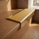 BN71SLR solid brass stair nosing in Antique Brass finish with Gold Castellated insert, fitted to a step edge