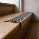 BN71SLR solid brass stair nosing in Antique Brass finish with Granite Castellated insert, fitted to a step edge