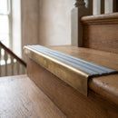 BN71SLR solid brass stair nosing in Antique Brass finish with Nimbus Castellated insert, fitted to a step edge