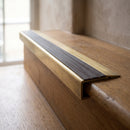 BN71SLR solid brass stair nosing in Antique Brass finish with Peat Castellated insert, fitted to a step edge