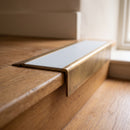 BN71SLR solid brass stair nosing in Antique Brass finish with Polar Grey Smooth Textured insert, fitted to a step edge