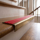 BN71SLR solid brass stair nosing in Antique Brass finish with Poppy Castellated insert, fitted to a step edge