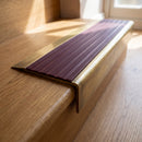 BN71SLR solid brass stair nosing in Antique Brass finish with Regency Castellated insert, fitted to a step edge