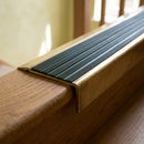 BN71SLR solid brass stair nosing in Antique Brass finish with Spruce Castellated insert, fitted to a step edge