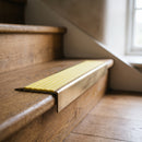 BN71SLR solid brass stair nosing in Antique Brass finish with Yellow Castellated insert, fitted to a step edge