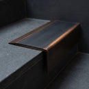 BN71SLR solid brass stair nosing in Antique Bronze finish with Black Smooth Textured insert, fitted to a step edge