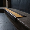 BN71SLR solid brass stair nosing in Antique Bronze finish with Gold Castellated insert, fitted to a step edge