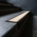 BN71SLR solid brass stair nosing in Antique Bronze finish with Ivory Castellated insert, fitted to a step edge