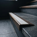 BN71SLR solid brass stair nosing in Antique Bronze finish with Light Grey Castellated insert, fitted to a step edge