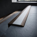 BN71SLR solid brass stair nosing in Antique Bronze finish with Light Grey Smooth Textured insert, fitted to a step edge