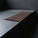 BN71SLR solid brass stair nosing in Antique Bronze finish with Peat Castellated insert, fitted to a step edge