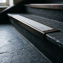 BN71SLR solid brass stair nosing in Antique Bronze finish with Polar Grey Castellated insert, fitted to a step edge