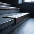 BN71SLR solid brass stair nosing in Antique Bronze finish with Polar Grey Smooth Textured insert, fitted to a step edge