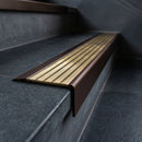 BN71SLR solid brass stair nosing in Antique Bronze finish with Polished Brass insert, fitted to a step edge