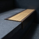 BN71SLR solid brass stair nosing in Antique Bronze finish with Satin Brass insert, fitted to a step edge