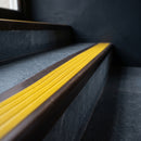 BN71SLR solid brass stair nosing in Antique Bronze finish with Yellow Castellated insert, fitted to a step edge