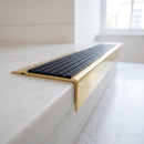BN71SLR solid brass stair nosing in Polished Brass finish with Black Castellated insert, fitted to a step edge