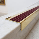 BN71SLR solid brass stair nosing in Polished Brass finish with Claret Castellated insert, fitted to a step edge