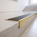 BN71SLR solid brass stair nosing in Polished Brass finish with Granite Castellated insert, fitted to a step edge