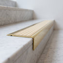 BN71SLR solid brass stair nosing in Polished Brass finish with Ivory Castellated insert, fitted to a step edge