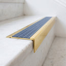 BN71SLR solid brass stair nosing in Polished Brass finish with Mid Blue Castellated insert, fitted to a step edge
