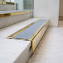 BN71SLR solid brass stair nosing in Polished Brass finish with Nimbus Castellated insert, fitted to a step edge