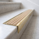 BN71SLR solid brass stair nosing in Polished Brass finish with Porth Stone Castellated insert, fitted to a step edge