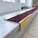 BN71SLR solid brass stair nosing in Polished Brass finish with Regency Castellated insert, fitted to a step edge