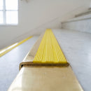 BN71SLR solid brass stair nosing in Polished Brass finish with Yellow Castellated insert, fitted to a step edge