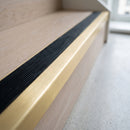 BN71SLR solid brass stair nosing in Satin Brass finish with Black Castellated insert, fitted to a step edge