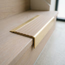 BN71SLR solid brass stair nosing in Satin Brass finish with Fawn Castellated insert, fitted to a step edge