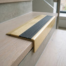 BN71SLR solid brass stair nosing in Satin Brass finish with Granite Castellated insert, fitted to a step edge