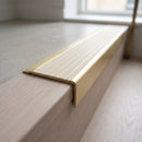 BN71SLR solid brass stair nosing in Satin Brass finish with Ivory Castellated insert, fitted to a step edge