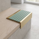 BN71SLR solid brass stair nosing in Satin Brass finish with Jade Castellated insert, fitted to a step edge