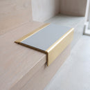 BN71SLR solid brass stair nosing in Satin Brass finish with Light Grey Smooth Textured insert, fitted to a step edge