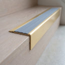 BN71SLR solid brass stair nosing in Satin Brass finish with Nimbus Castellated insert, fitted to a step edge