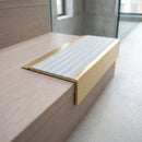 BN71SLR solid brass stair nosing in Satin Brass finish with Polar Grey Castellated insert, fitted to a step edge