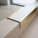 BN71SLR solid brass stair nosing in Satin Brass finish with Polar Grey Smooth Textured insert, fitted to a step edge