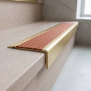 BN71SLR solid brass stair nosing in Satin Brass finish with Rustic Castellated insert, fitted to a step edge