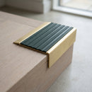 BN71SLR solid brass stair nosing in Satin Brass finish with Spruce Castellated insert, fitted to a step edge