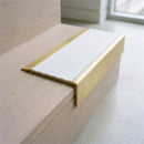 BN71SLR solid brass stair nosing in Satin Brass finish with White Castellated insert, fitted to a step edge